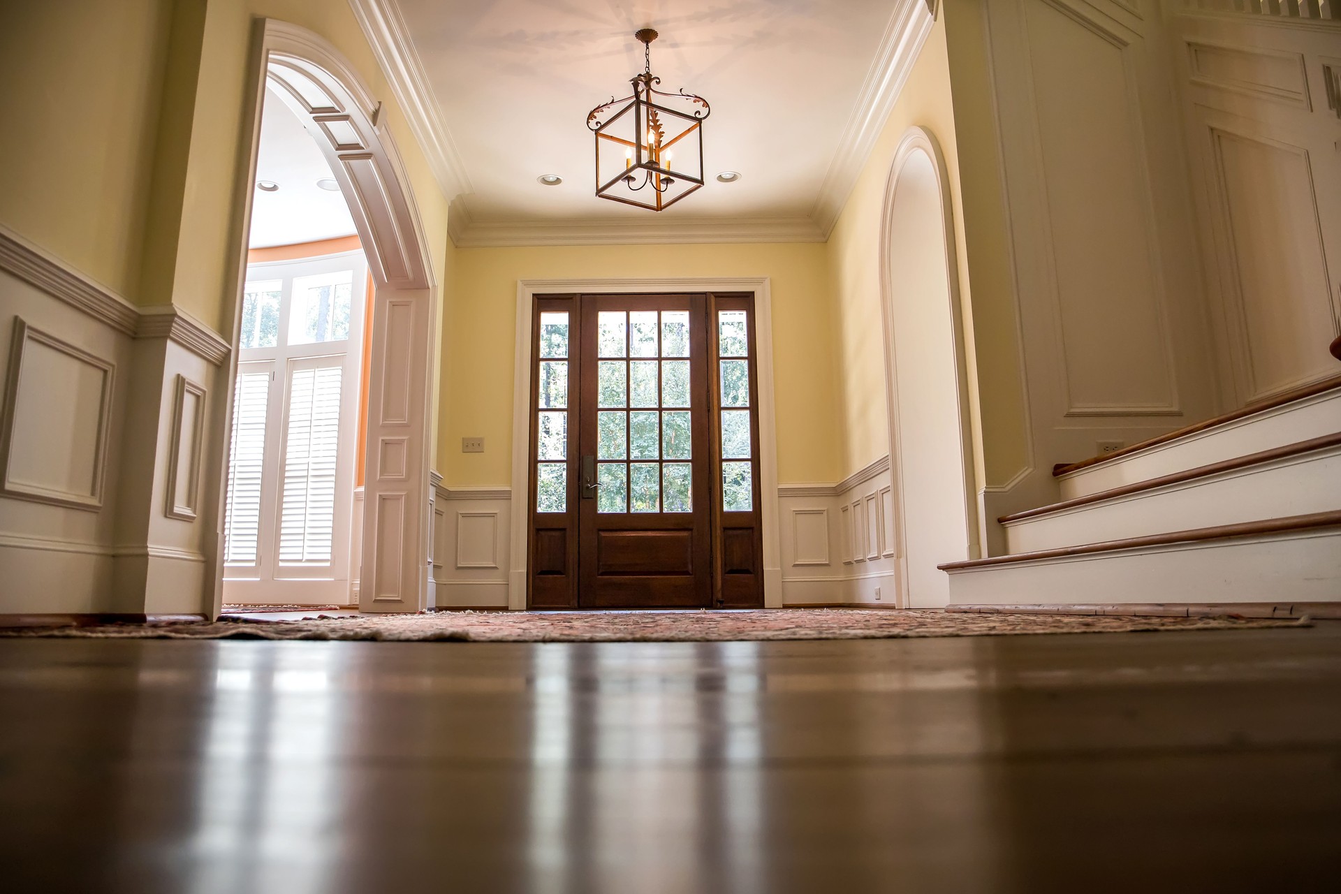 Grand and elegant yellow entrance to a home with stairs
